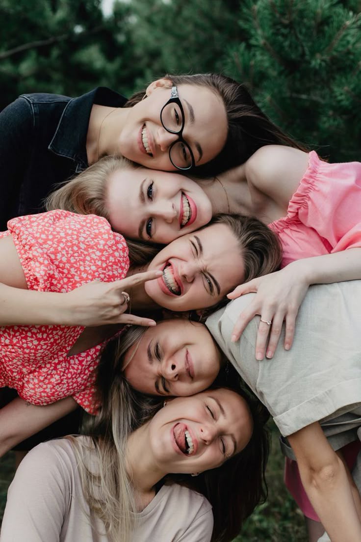 Amigas sorrindo deitadas juntas ao ar livre